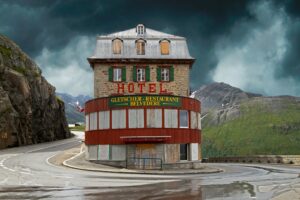 red and brown concrete building near mountain under white clouds during daytime